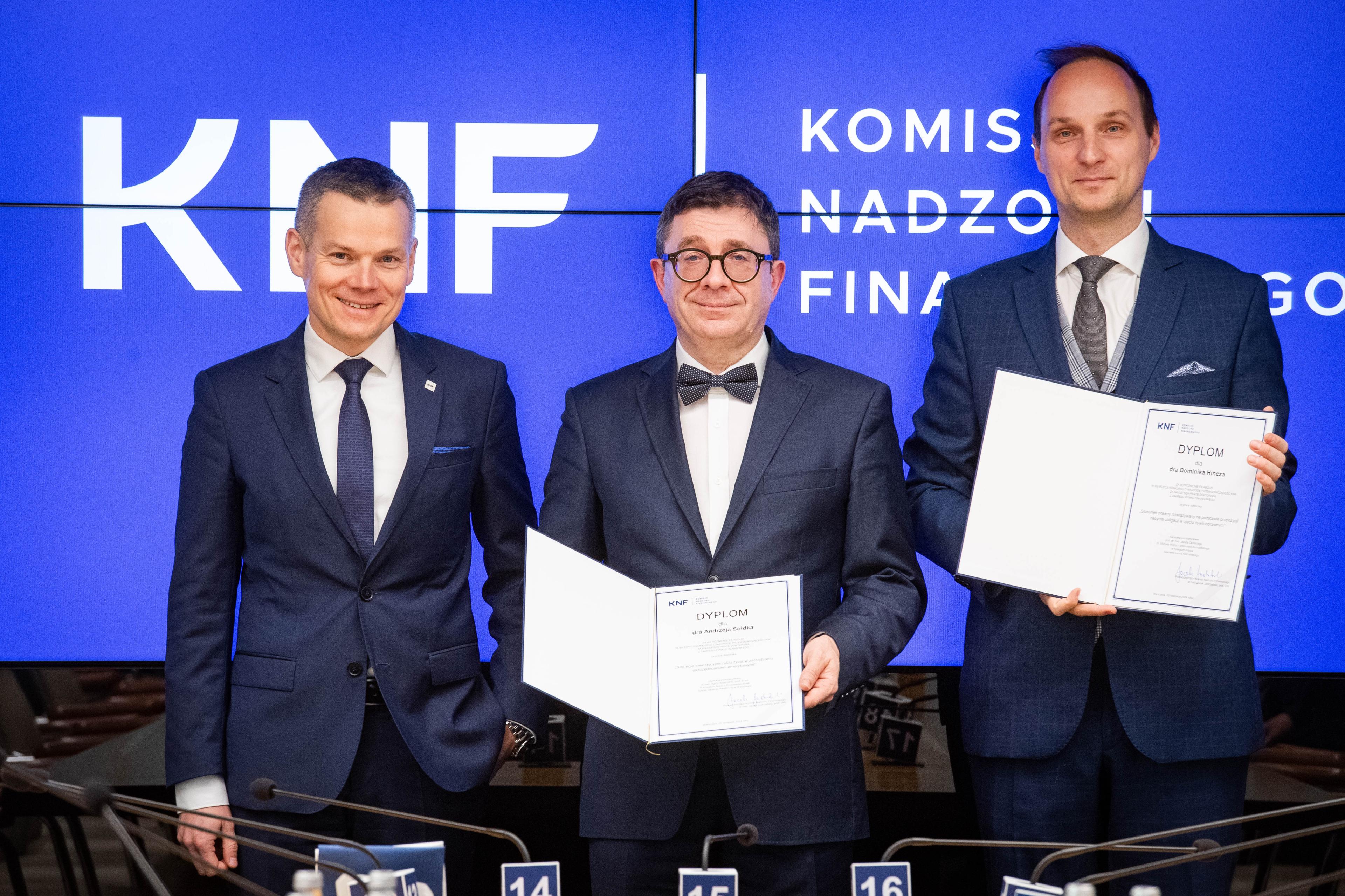 Zdjęcie Przewodniczącego KNF i autorów wyróżnionych ex aequo prac doktorskich